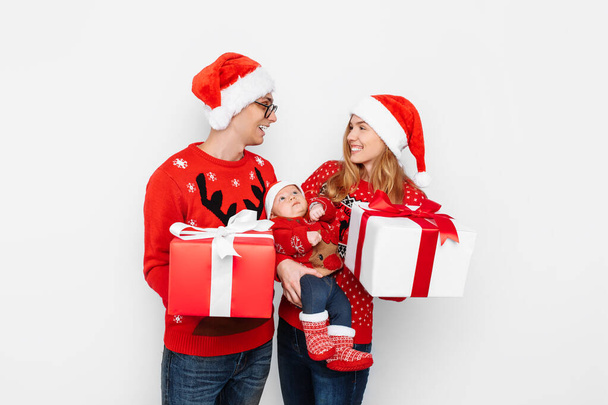 Happy family, mom, dad and little baby with christmas gifts isolated on white background - Foto, afbeelding