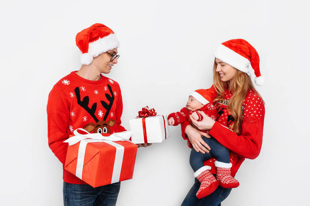 Happy family, dad mom and little baby, celebrate Christmas and give Christmas presents, on a white background - Foto, Imagem