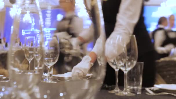 Číšník prostře stůl v restauraci, než dorazí zákazníci, a použije jemné příbory a sklenice. Koncept: catering, design, romantické večeře. Luxusní catering pozadí. Nápad na oslavu - Záběry, video