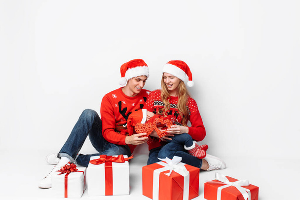 Happy loving family, dad, mom and baby, celebrate Christmas, sitting on a white background - Foto, Imagen