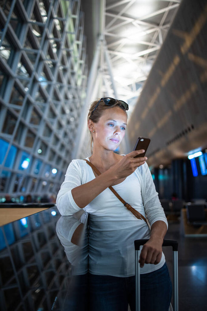 Nuori nainen matkatavaroineen kansainvälisellä lentokentällä
 - Valokuva, kuva