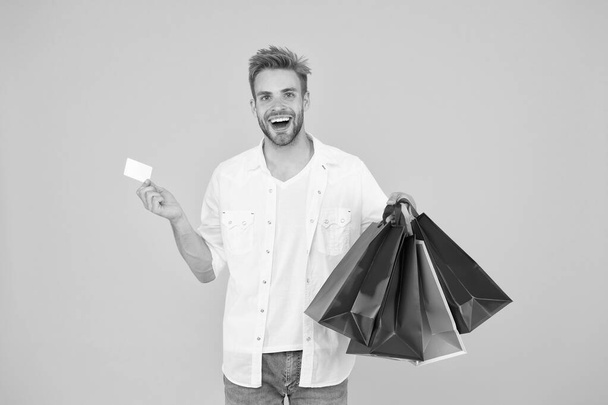 Big discount. Great choices great purchases. Happy man holding purchases in paper bags. Cheerful client customer consumer smiling with fashion purchases. Impulse purchases. Consumerism concept - Photo, image