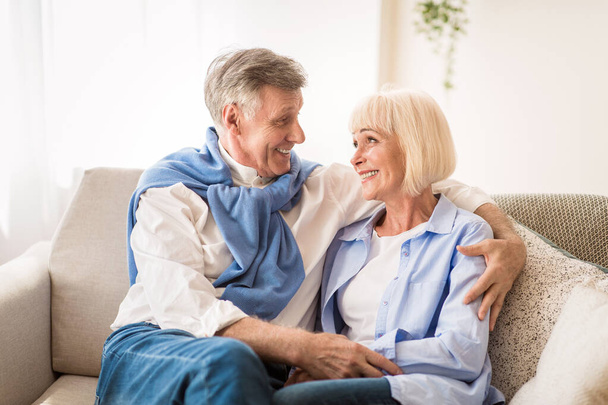 glückliches Senioren-Paar schaut einander an, entspannt zu Hause - Foto, Bild