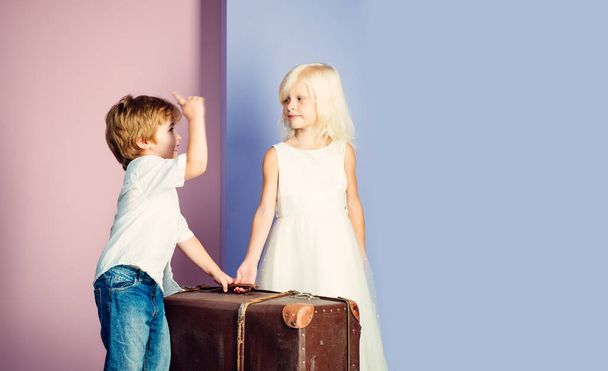 Relocation concept. Couple kids with suitcase. Happy childhood. Boy and girl cute friends. Friendship and love. Lovely tender children. Small kids friendship. Sincere friendship. We are moving on - Zdjęcie, obraz