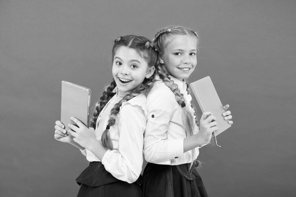 These books are absolutely genius. Genius little children smiling on red background. Happy genius girls or wonder kids with books. Small schoolgirls holding books with genius ideas - Foto, Imagem