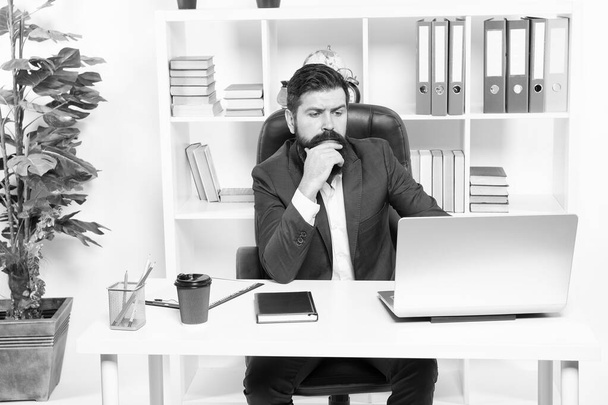 Broker tracks financial indicators. Man bearded hipster boss sit in leather armchair office interior. Boss at workplace. Manager formal corporate style working. Business people. Busy boss in office - 写真・画像