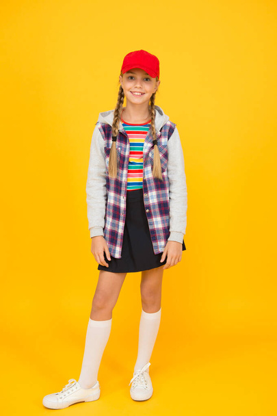 Modern outfit. Rebellious teen. Street style. Cool schoolgirl. Have fun charismatic girl on yellow background. Tomboy concept. Teen age. Girl adorable stylish outfit teenager. Comfortable outfit - Photo, Image