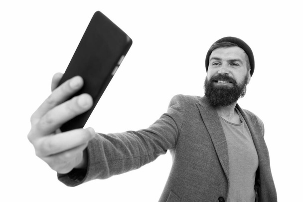 His best selfie is yet to come. Bearded man smiling to selfie camera. Happy hipster taking selfie with smartphone in hand. Perfect selfie from any angle - Foto, Imagem