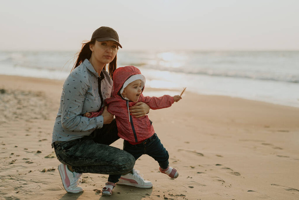Matka i córeczka bawią się na plaży. Autentyczne zdjęcie - Zdjęcie, obraz