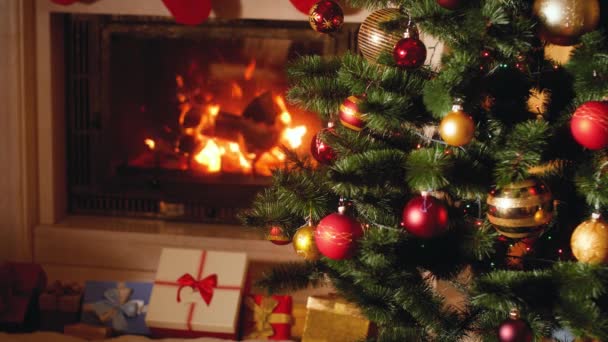 Vídeo 4k de grande pilha de presentes e presente ao lado de lareira em chamas e árvore de Natal brilhante na sala de estar na véspera de Natal
 - Filmagem, Vídeo