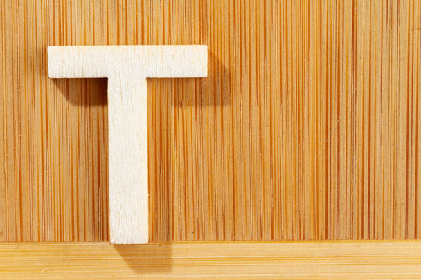 Letter T of wood-made alphabet, top view and space for text - Photo, Image