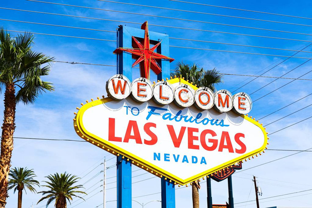 Las Vegas 'ın parlak güneşli günündeki Muhteşem Las Vegas tabelasına hoş geldiniz. Arka planda Las Vegas' ın kalbinin olduğu Las Vegas, Nevada 'nın Uykusuz Şehri tabelasına hoş geldiniz.. - Fotoğraf, Görsel
