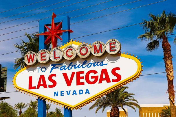 Las Vegas 'ın parlak güneşli günündeki Muhteşem Las Vegas tabelasına hoş geldiniz. Arka planda Las Vegas' ın kalbinin olduğu Las Vegas, Nevada 'nın Uykusuz Şehri tabelasına hoş geldiniz.. - Fotoğraf, Görsel