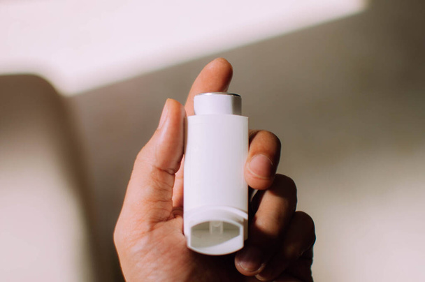 A young person is holding an asthma inhaler device - Photo, Image