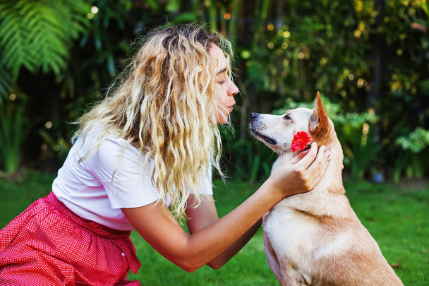 Muito jovem caucasiano mulher beijando um nariz de seu cão de estimação
 - Foto, Imagem
