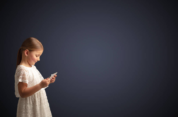 Cute little girl using tablet with dark background - Fotografie, Obrázek
