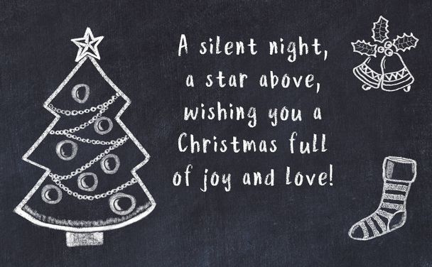 Drawing of christmas tree and handwritten greetings on black chalkboard  - Фото, зображення