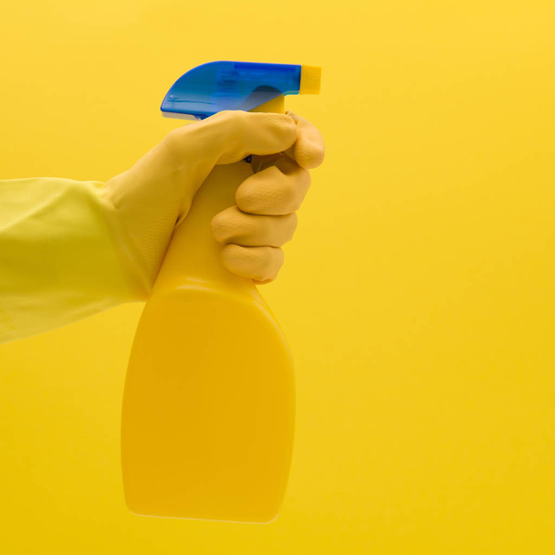 Hand in yellow rubber glove with cleaning product - Foto, Bild