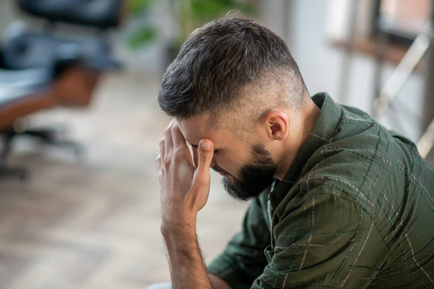 Bearded man wearing checked shirt having strong headache - Фото, зображення