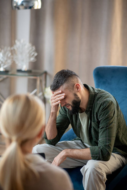Dark-haired man talking about depression to psychologist - Фото, зображення