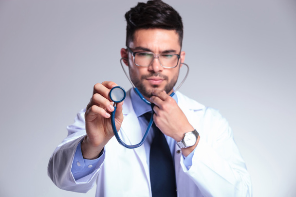 young doctor listens concentrated at stethoscope - Фото, зображення