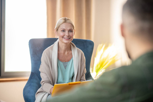 Beautiful psychoanalyst smiling while talking to client - Φωτογραφία, εικόνα