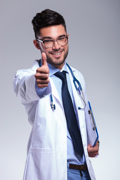 fiatal orvos azt mutatja, hüvelykujj fel és mosolyog - Fotó, kép