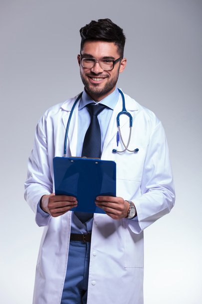 młody lekarz z schowka w ręce - Zdjęcie, obraz