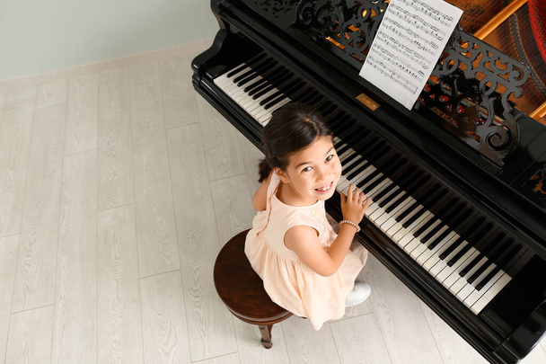 Menina tocando piano de cauda em casa, vista superior
 - Foto, Imagem