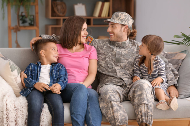 Onnellinen sotilas perheensä kanssa kotona
 - Valokuva, kuva