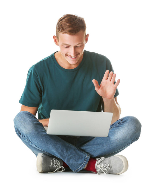 Young man in stylish t-shirt and with laptop on white background - Foto, Imagen