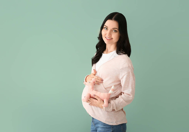 Beautiful young pregnant woman on color background - Фото, зображення