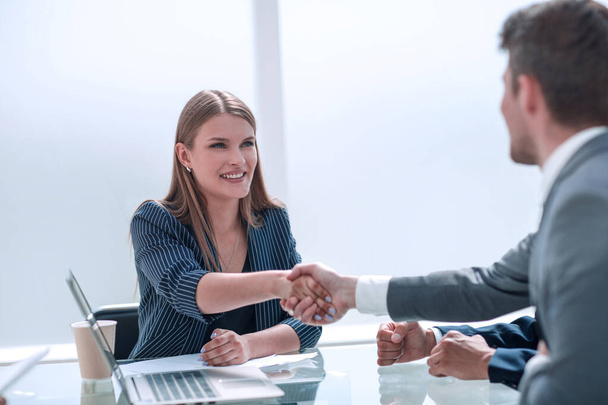 businessman shaking hands with businesswoman sitting at the negotiating table - Foto, Imagem