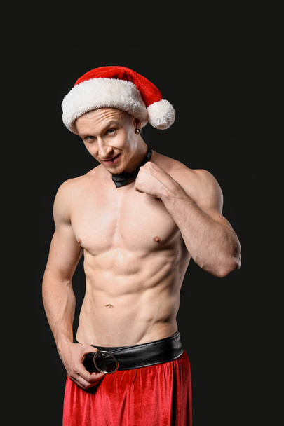 junger athletischer Weihnachtsmann auf dunklem Hintergrund - Foto, Bild