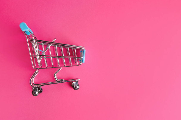 Empty small shopping cart on color background - Photo, Image