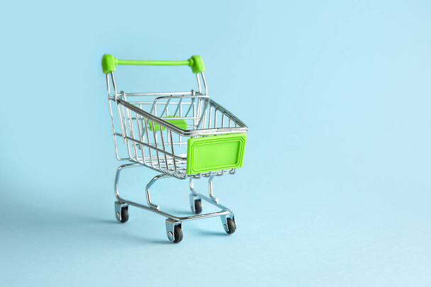 Prázdný malý nákupní košík na barevném pozadí - Fotografie, Obrázek