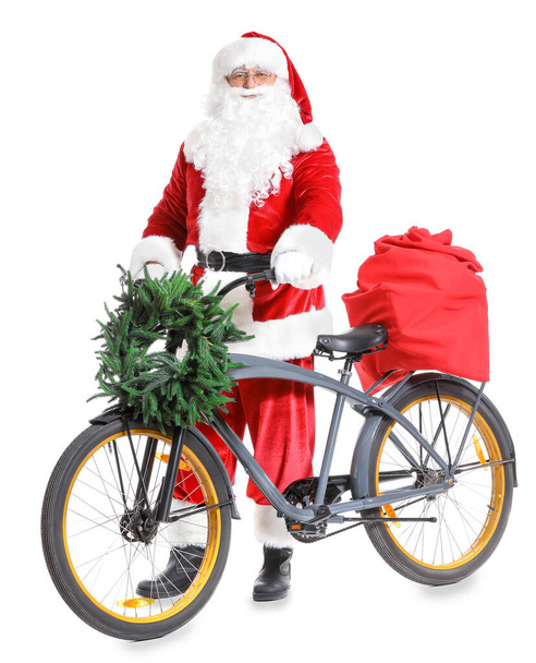 Weihnachtsmann mit Weihnachtsgeschenken und Fahrrad auf weißem Hintergrund - Foto, Bild