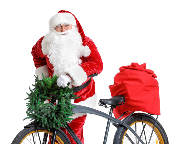 Weihnachtsmann mit Weihnachtsgeschenken und Fahrrad auf weißem Hintergrund - Foto, Bild
