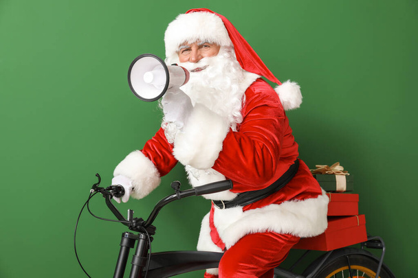 Santa Claus z megafonem i rower na tle koloru - Zdjęcie, obraz