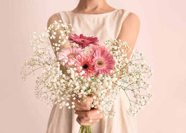 Woman with bouquet of beautiful flowers on color background - Foto, Bild