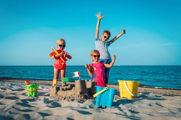 幸せな子供たち - 男の子と女の子 - ビーチで砂と遊ぶ - 写真・画像