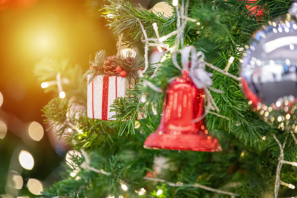Feliz ano novo e ornamentos na árvore de Natal com caixa de presente
 - Foto, Imagem