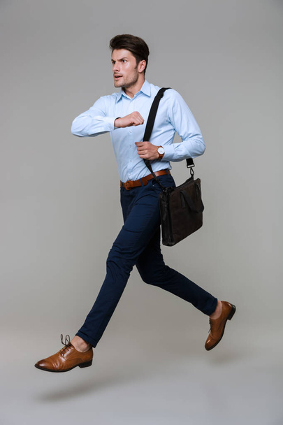 Full length portrait of concentrated young businessman running a - Foto, afbeelding