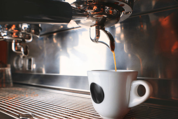 Stijlvolle zwarte espresso machine brouwen van twee kopjes koffie, opgenomen in cafe. - Foto, afbeelding