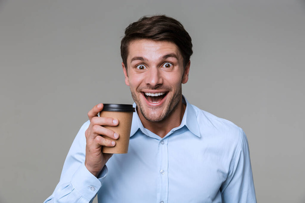 Image of caucasian businessman drinking coffee from paper cup - Fotó, kép