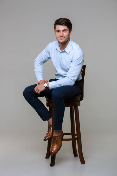 Full length portrait of caucasian young businessman sitting on c - Photo, image