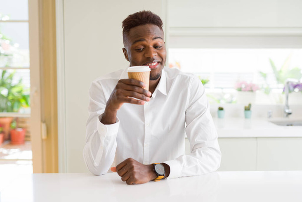 Afro-Américain souriant confiant boire un café dans une tasse en papier à emporter
 - Photo, image