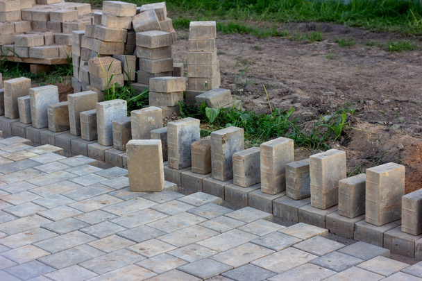 Piedras y ladrillos de pavimento de construcción en terraza, carretera o acera en la calle de la ciudad
. - Foto, imagen