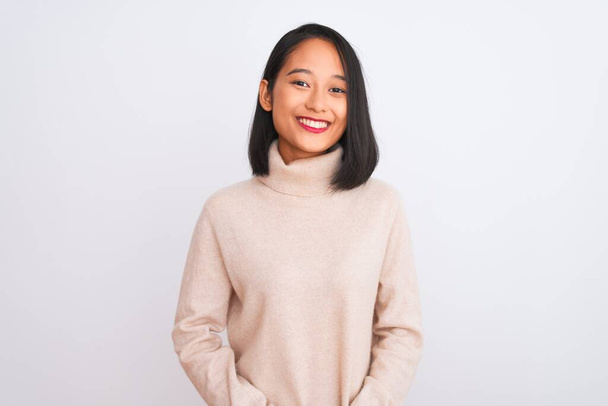 Mulher chinesa jovem vestindo camisola gola alta em pé sobre fundo branco isolado com as mãos juntas e dedos cruzados sorrindo relaxado e alegre. Sucesso e otimista
 - Foto, Imagem