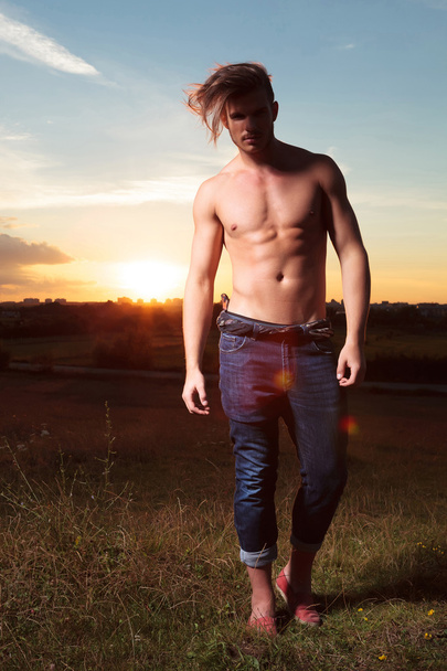 топлес чоловік стоїть на заході сонця
 - Фото, зображення
